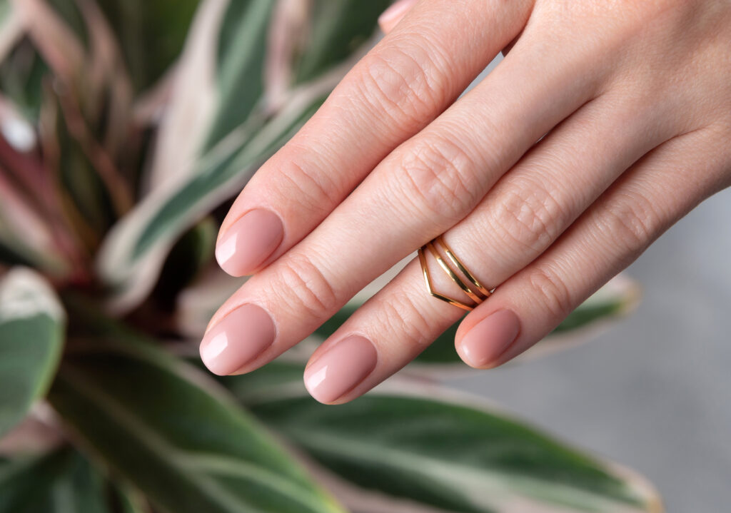 Womans,Hand,With,Nude,Beige,Pink,Nail,Design,On,Houseplant