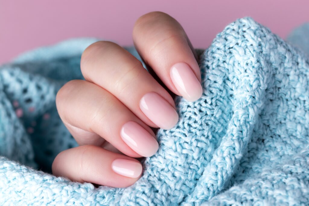 Female,Hand,In,Blue,Knitted,Sweater,With,Beautiful,Natural,Manicure